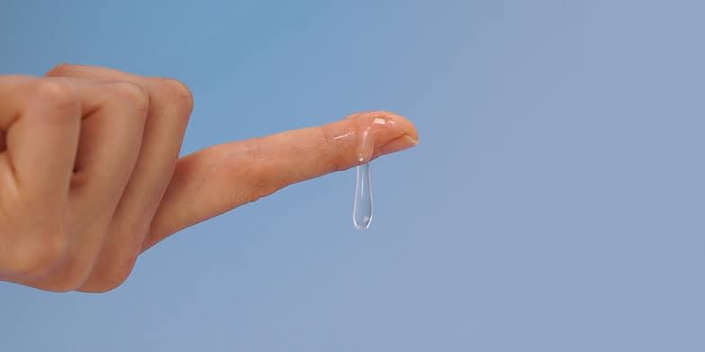 Hand holding up lube used for making a girl cum during sex